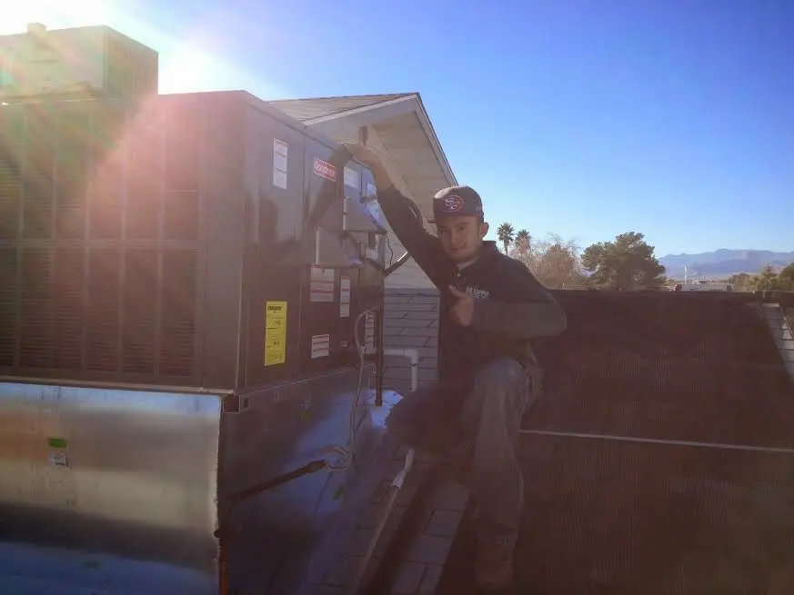 HVAC technician performing AC Tune-Up on a rooftop unit in New Philadelphia
